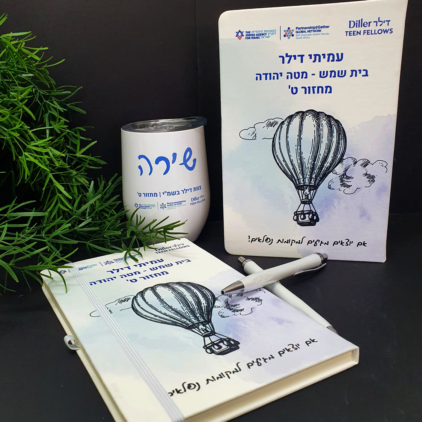 עיצוב והדפסת מחברות כריכה קשה דמוי עור עבור תכנית עמיתי דילר בית שמש מטה יהודה בעיצוב כדור פורח וכוס תרמית תואמת